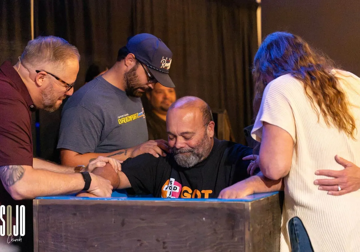 Pastors praying over someone at the SOJO baptism tank