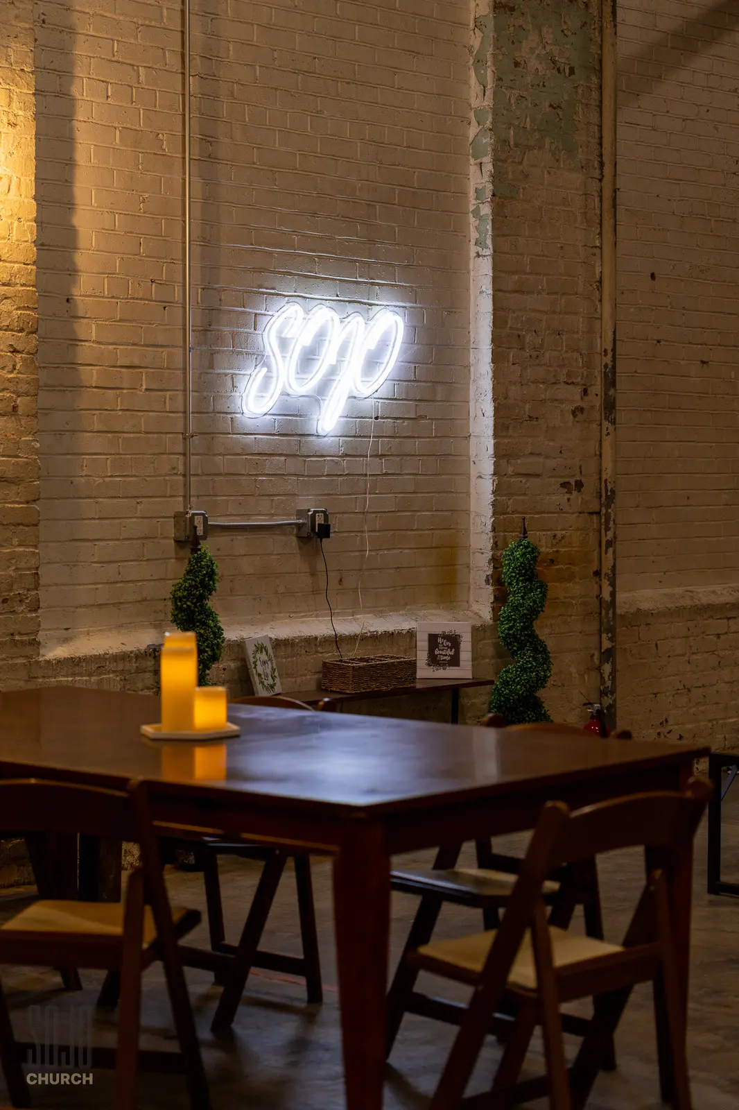 The neon SOJO sign glowing on the brick wall of the cafe area