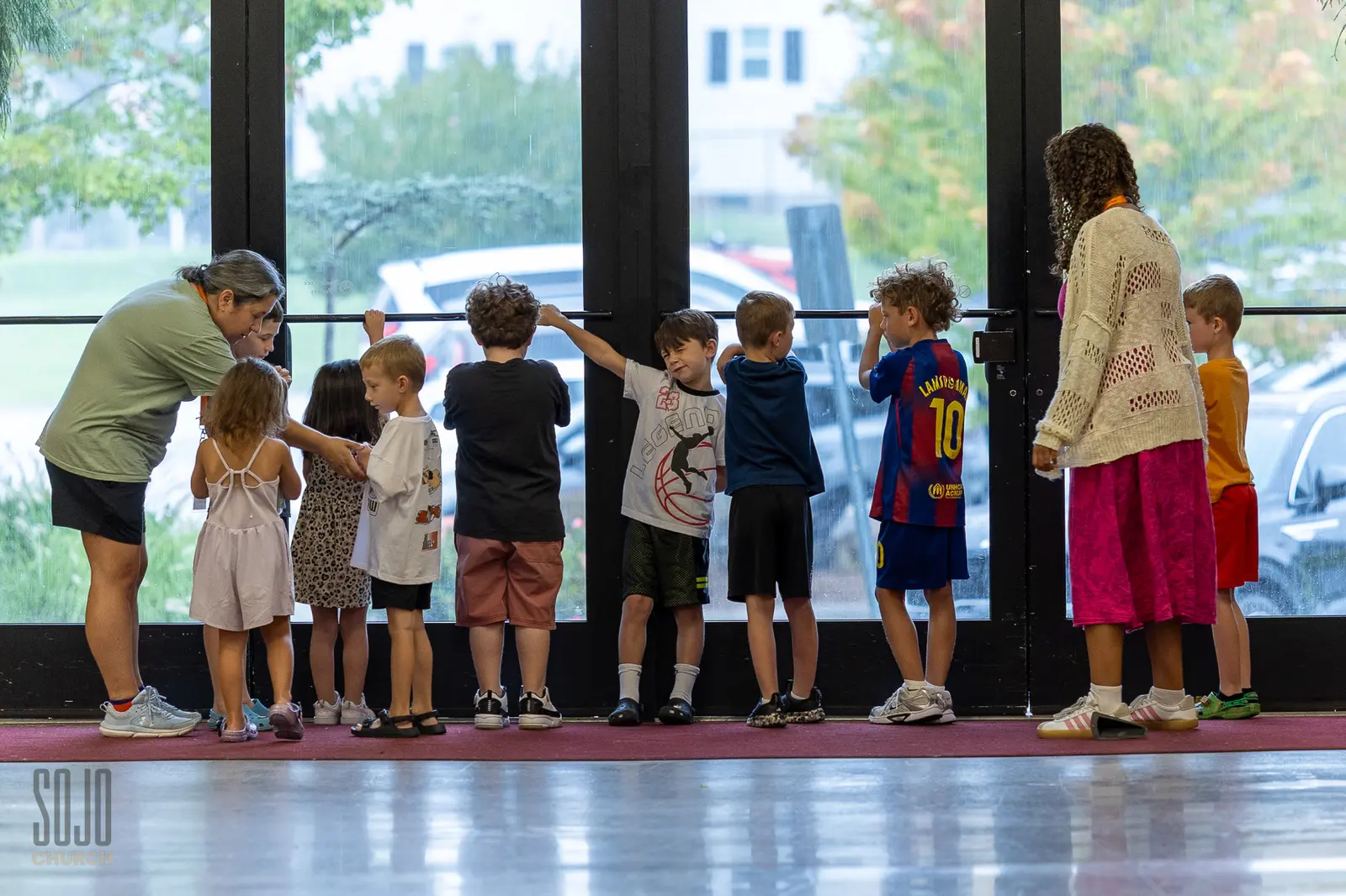 SOJO Kids gathered at the tall mill windows with their leaders