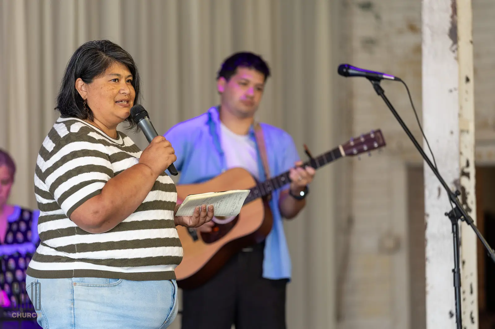 A woman sharing her story on stage at SOJO Church