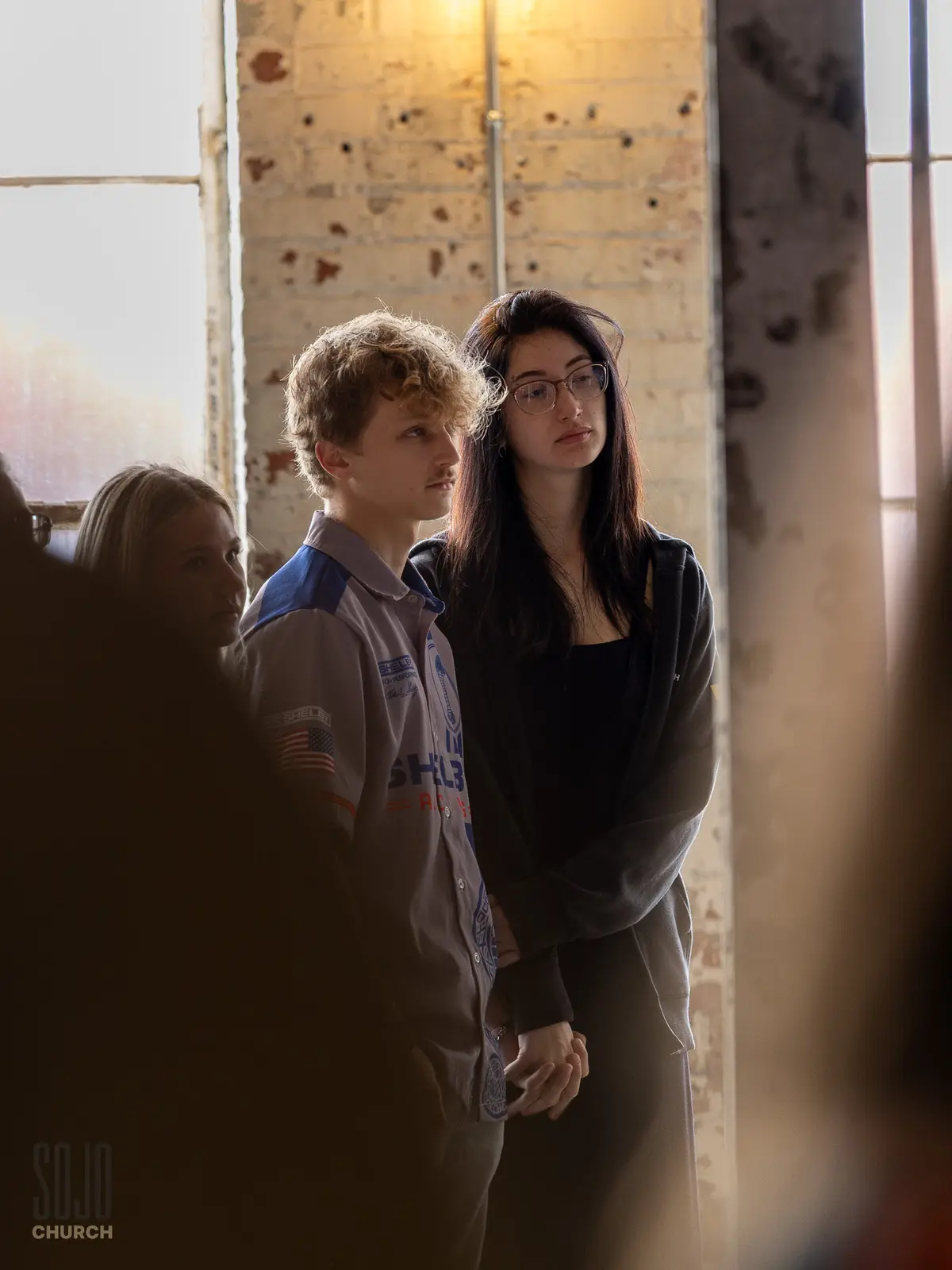 Two SOJO young adults standing together in worship