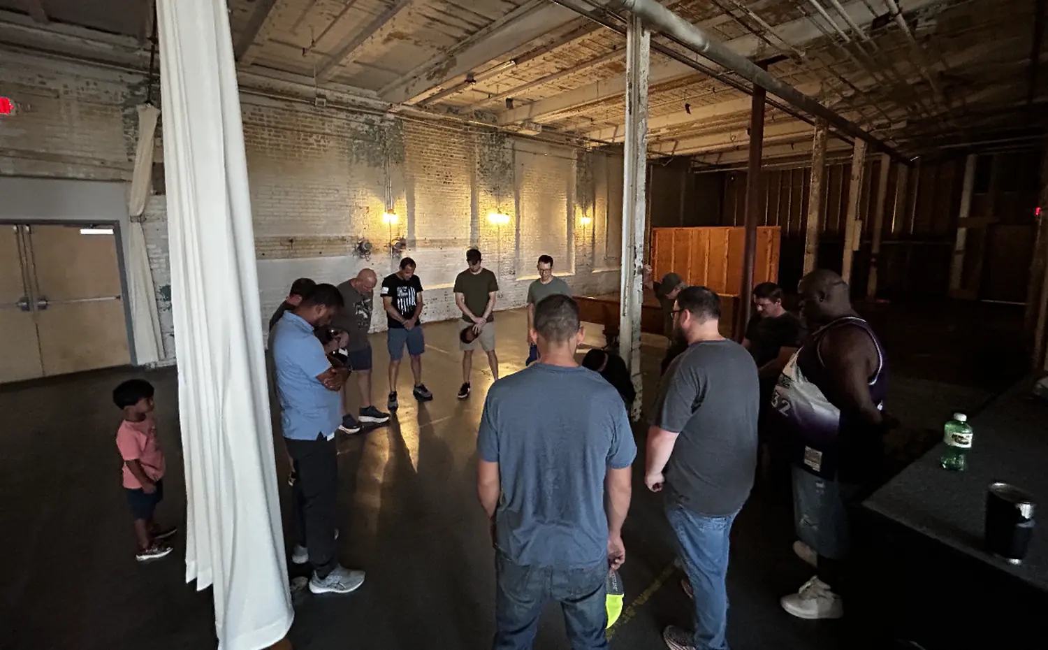 A SOJO group praying in a circle at the mill