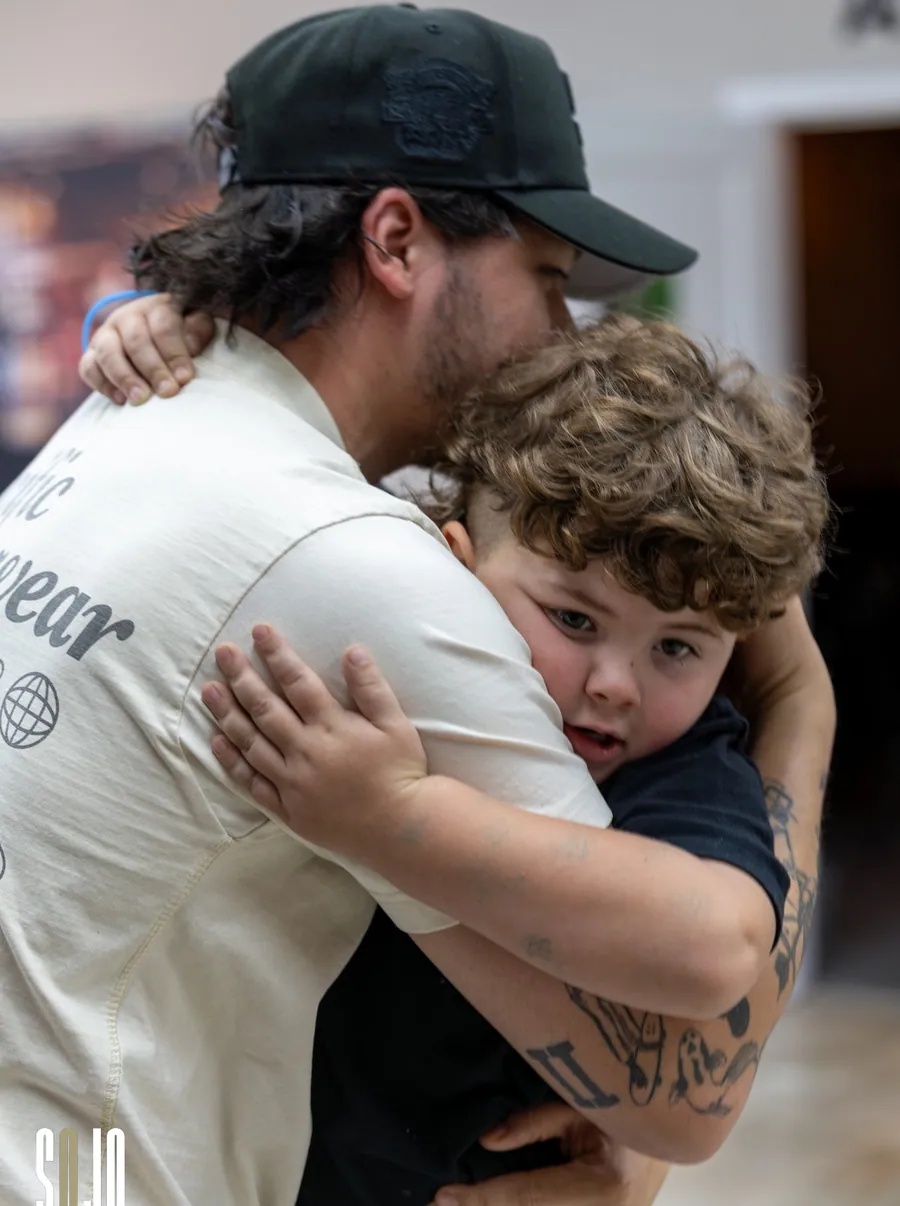A SOJO volunteer holding a child after a service