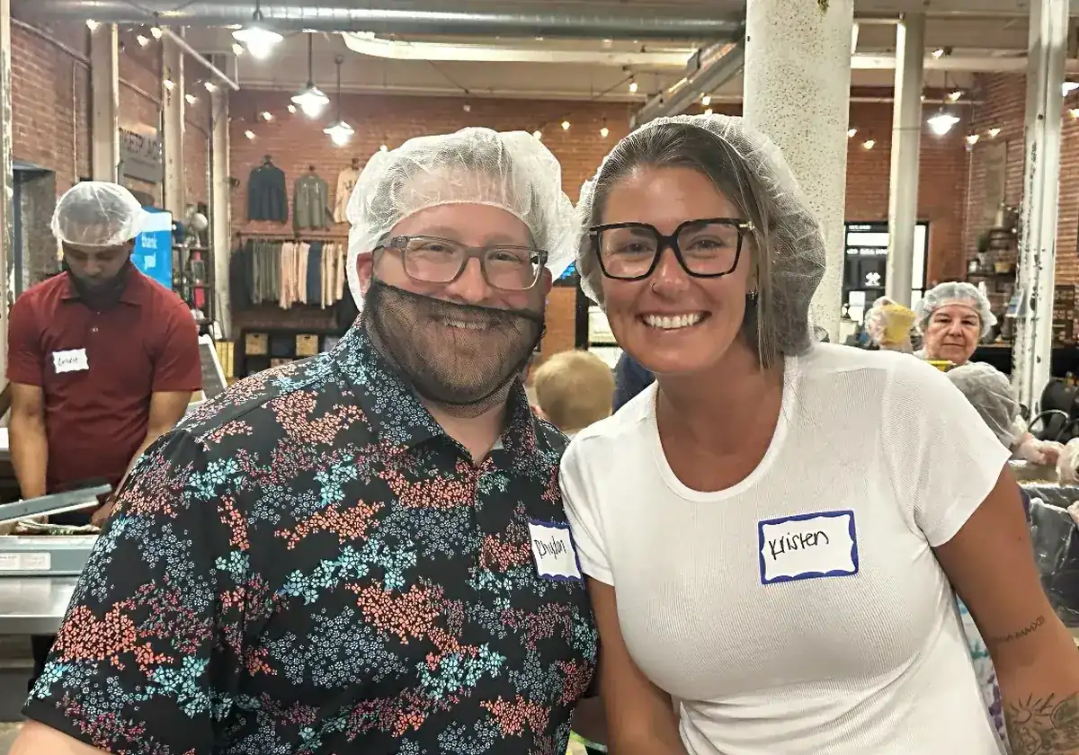 Two SOJO volunteers in hairnets at a packing event