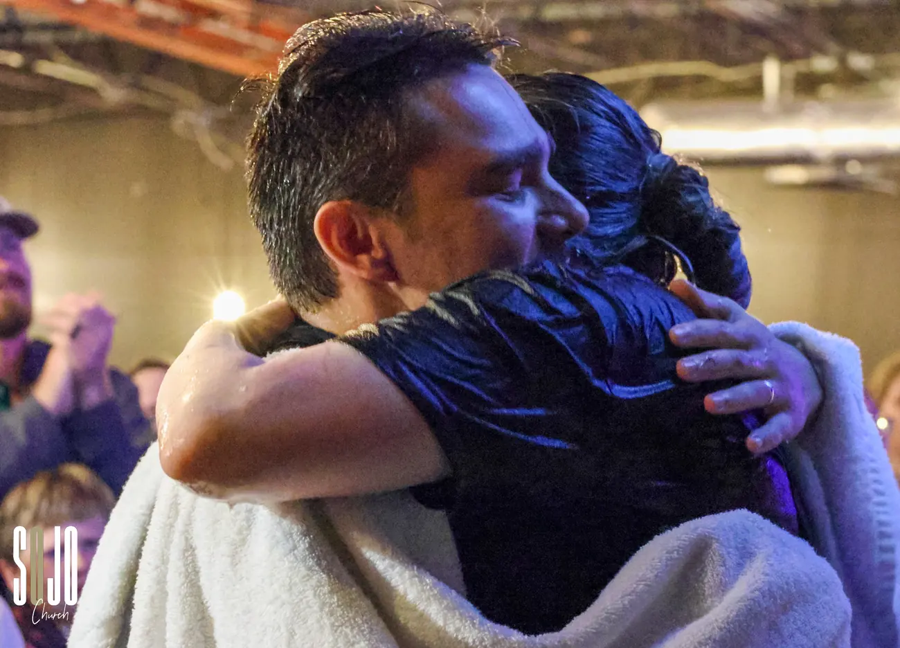 A soaking-wet baptism hug at SOJO Church