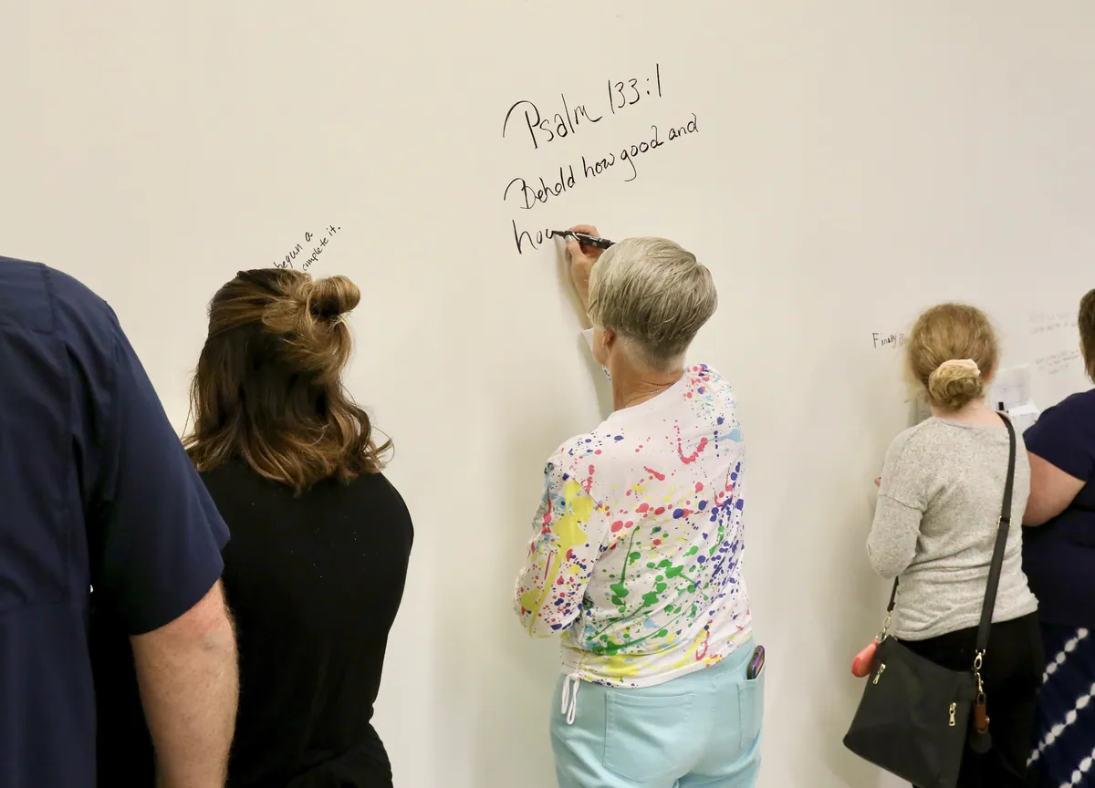 Church members writing Scripture on the wall before it was painted