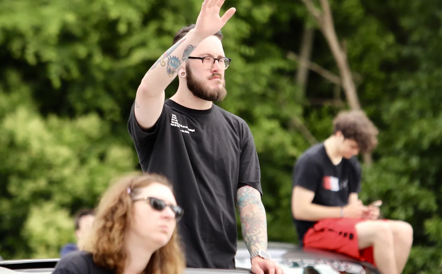 A man worshipping while standing on a car roof at drive-in church