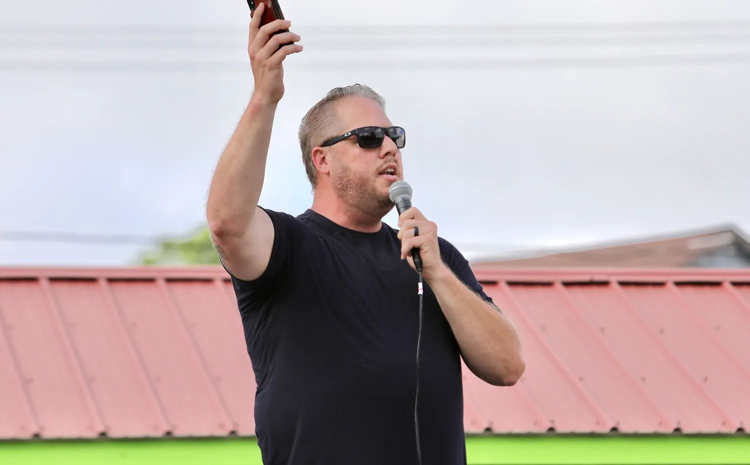 Pastor Corey preaching outdoors with his phone raised in 2020
