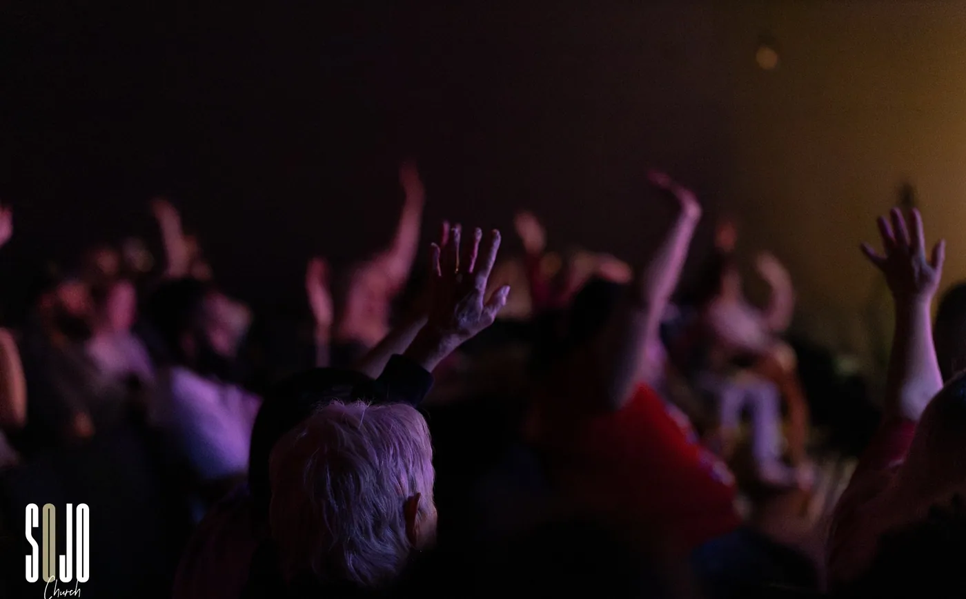 A SOJO congregation with hands raised in worship