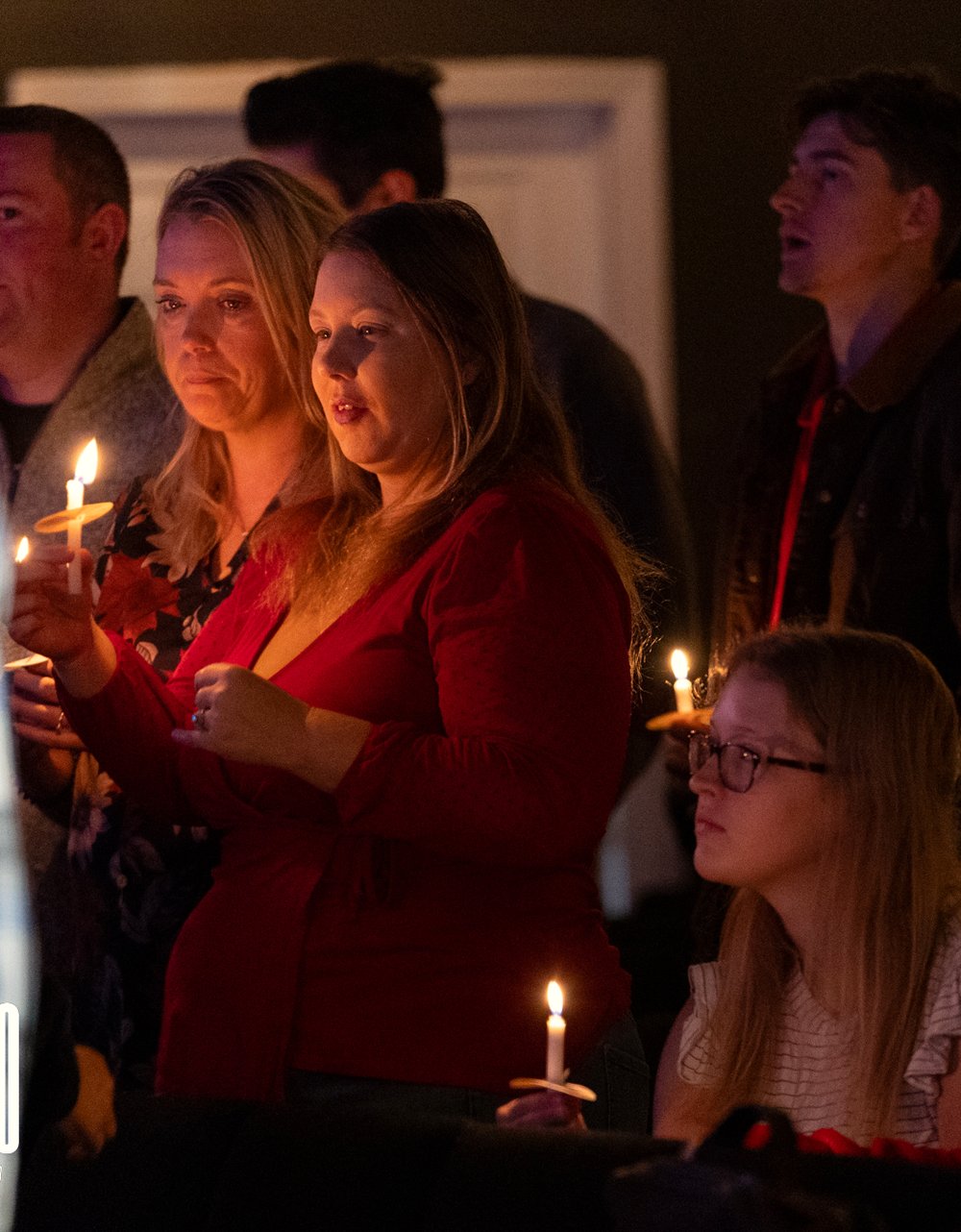 The whole room holding candles at a SOJO candlelight service