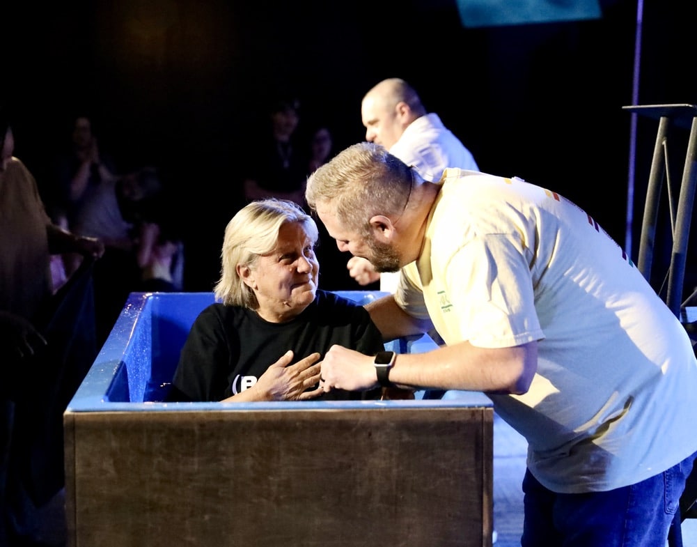 7BAE9451-2699-4B89-8F69-5E7F48E4CBC9_1_105_c Man baptizing woman in church ceremony